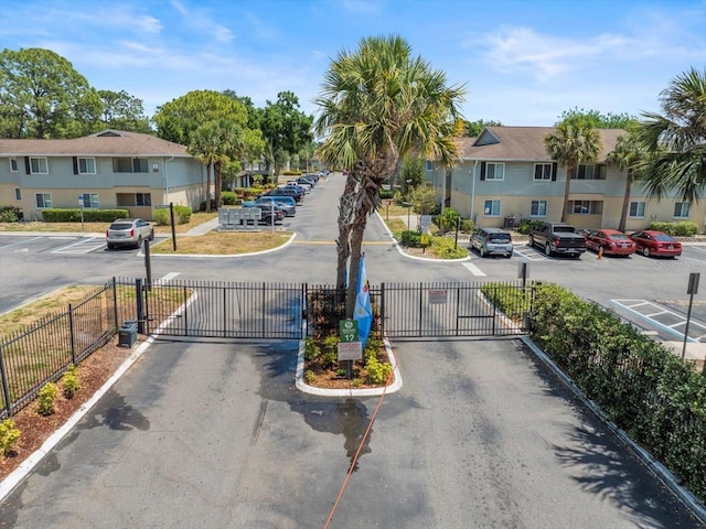 view of street featuring a residential view, curbs, and a gate