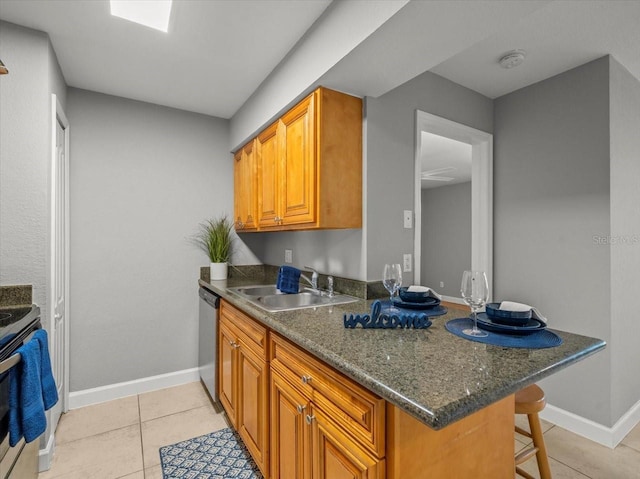 kitchen featuring a sink, brown cabinets, stainless steel appliances, and baseboards