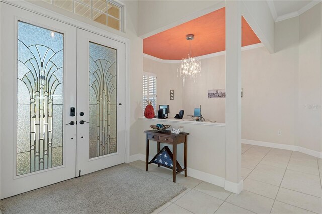 tiled foyer entrance featuring a chandelier, french doors, and a healthy amount of sunlight