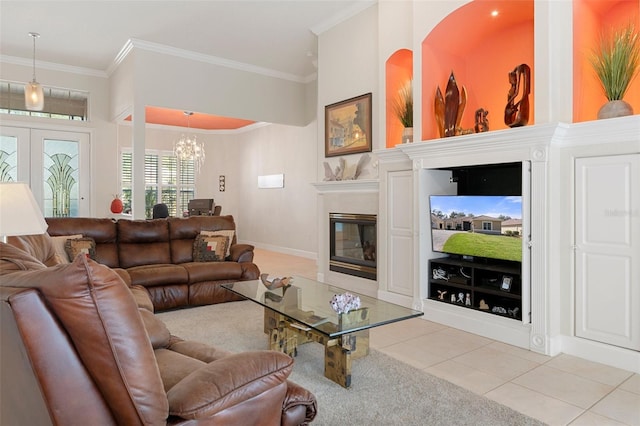 living room with a notable chandelier, light tile patterned floors, ornamental molding, and french doors