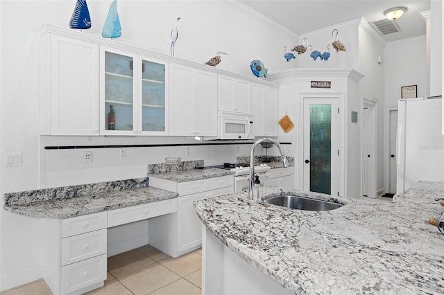 kitchen featuring decorative backsplash, white cabinetry, white appliances, and crown molding