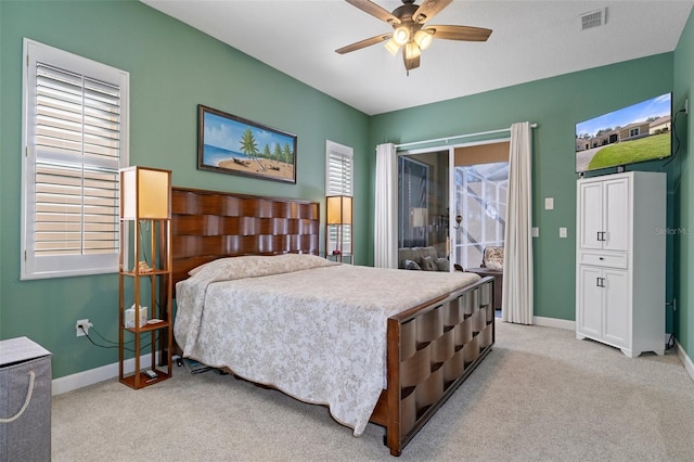 bedroom with access to exterior, ceiling fan, light carpet, and multiple windows