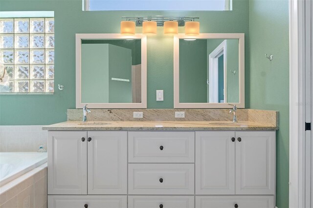 bathroom with vanity and tiled bath