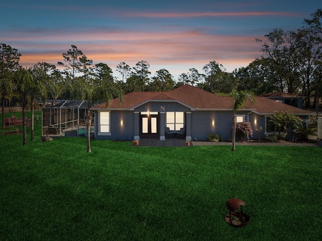 view of front of home featuring a pool, a yard, and a lanai