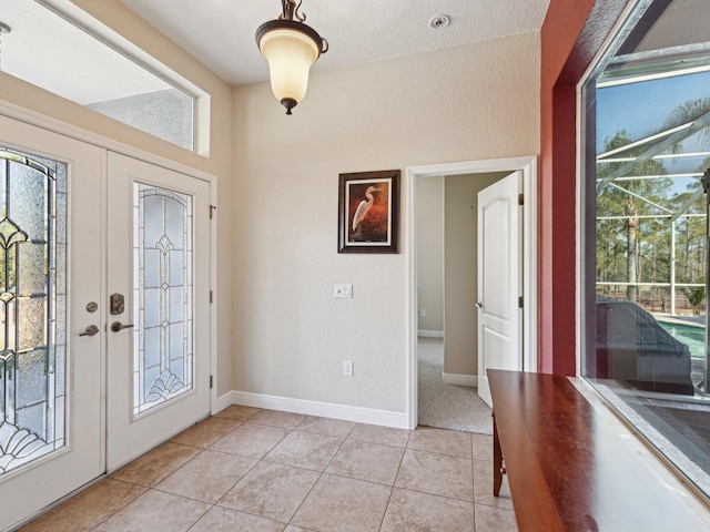 tiled foyer entrance featuring a textured ceiling and french doors