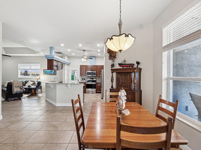 dining space with ceiling fan, sink, and light tile patterned floors