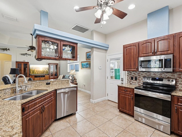 kitchen featuring sink, light tile patterned floors, appliances with stainless steel finishes, ceiling fan, and backsplash