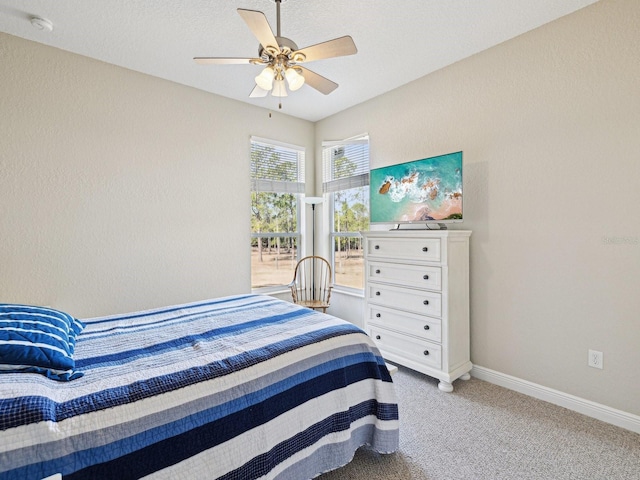 bedroom featuring light carpet, a textured ceiling, and ceiling fan