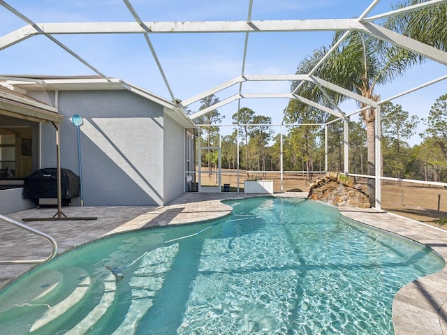 view of swimming pool featuring a patio, area for grilling, and glass enclosure