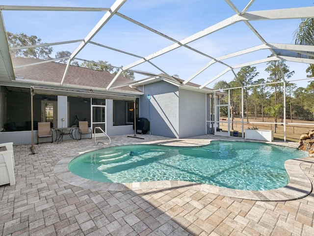 view of swimming pool with a lanai, ceiling fan, and a patio area