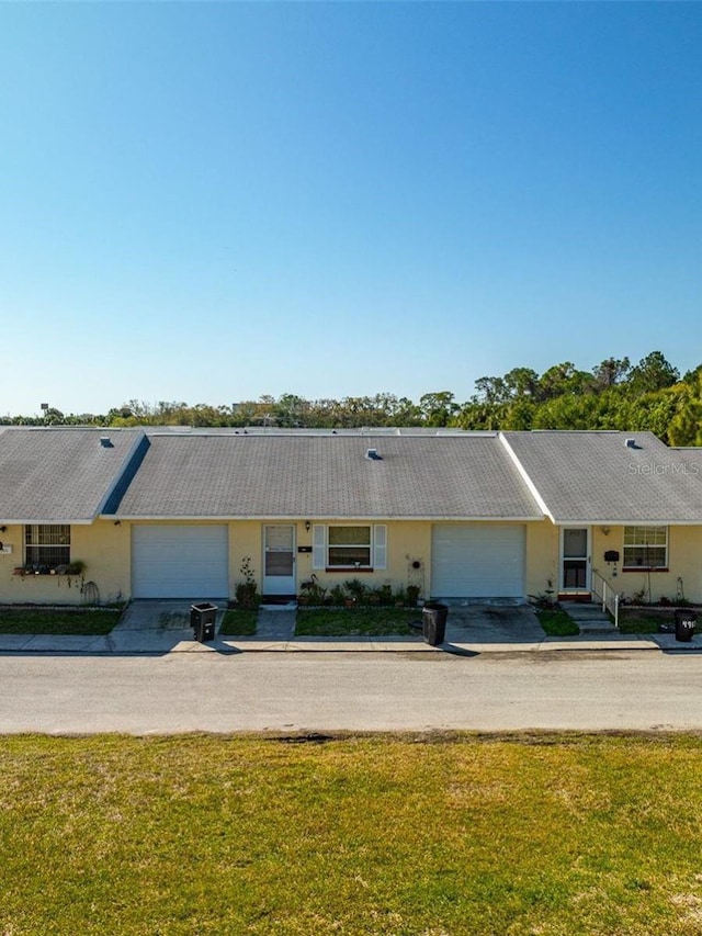 ranch-style home featuring a front lawn and a garage