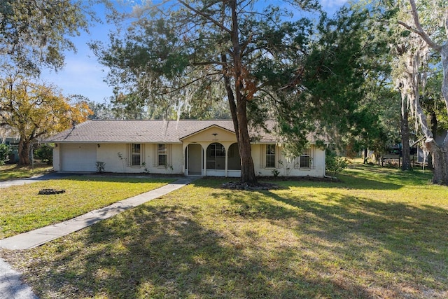 single story home featuring a front yard, a porch, and a garage