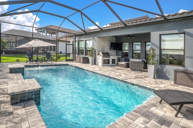 view of pool with an outdoor kitchen, pool water feature, ceiling fan, and a patio area