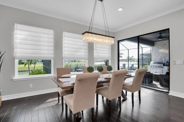 dining room with dark hardwood / wood-style floors, ornamental molding, and an inviting chandelier