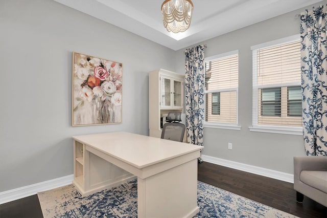 home office featuring dark hardwood / wood-style flooring and a notable chandelier