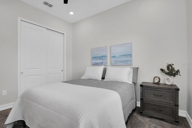 bedroom featuring dark colored carpet, a closet, and ceiling fan