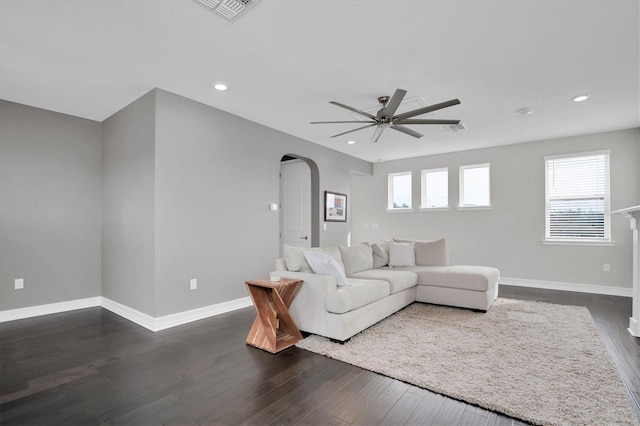 living room with dark hardwood / wood-style flooring and ceiling fan