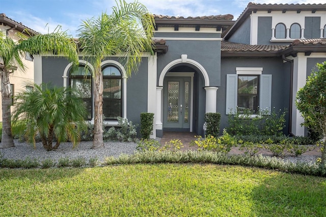 view of front of home featuring a front yard and french doors