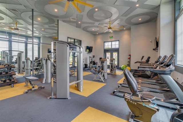 workout area featuring ceiling fan, coffered ceiling, and a high ceiling