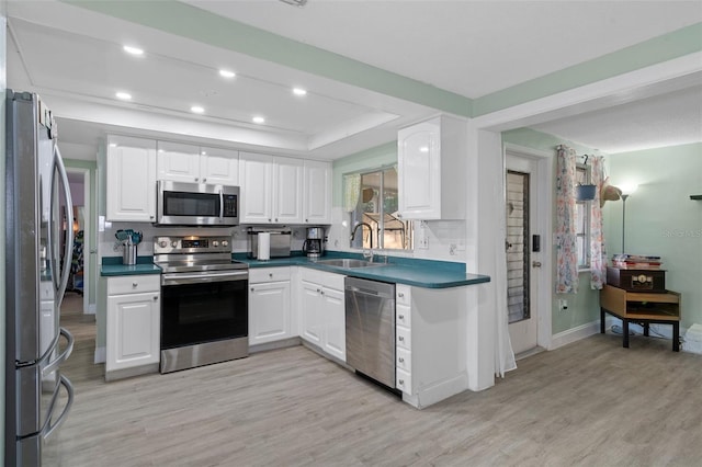 kitchen featuring white cabinets, stainless steel appliances, and light hardwood / wood-style floors