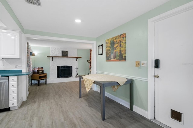 rec room featuring a fireplace and light hardwood / wood-style floors