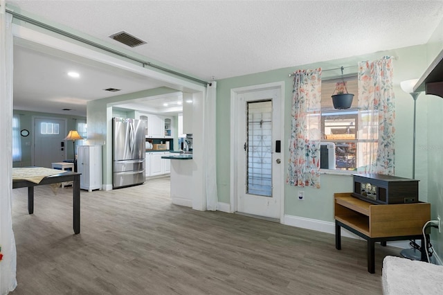 entrance foyer with hardwood / wood-style floors and a textured ceiling