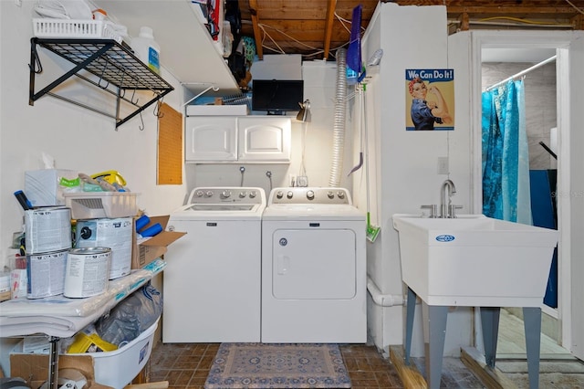 washroom with cabinets, sink, and washing machine and dryer