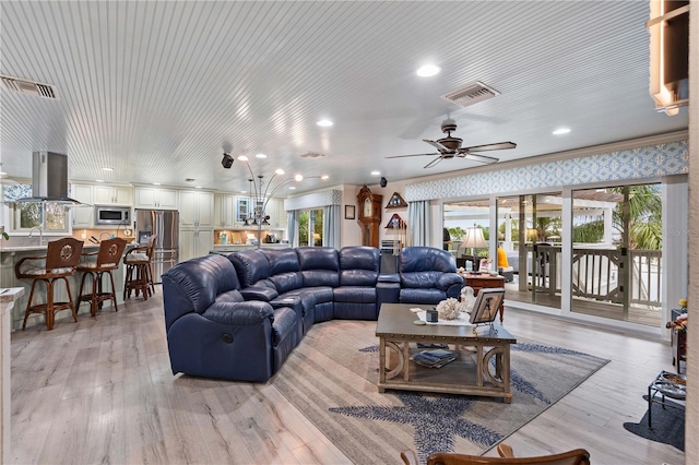 living room with light hardwood / wood-style floors, ceiling fan, ornamental molding, and sink