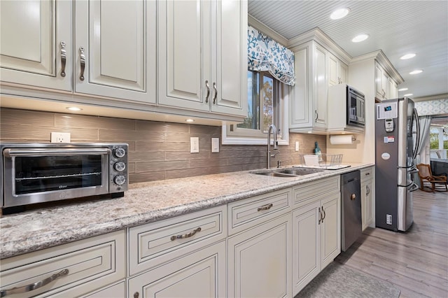 kitchen featuring backsplash, crown molding, sink, light hardwood / wood-style floors, and stainless steel appliances