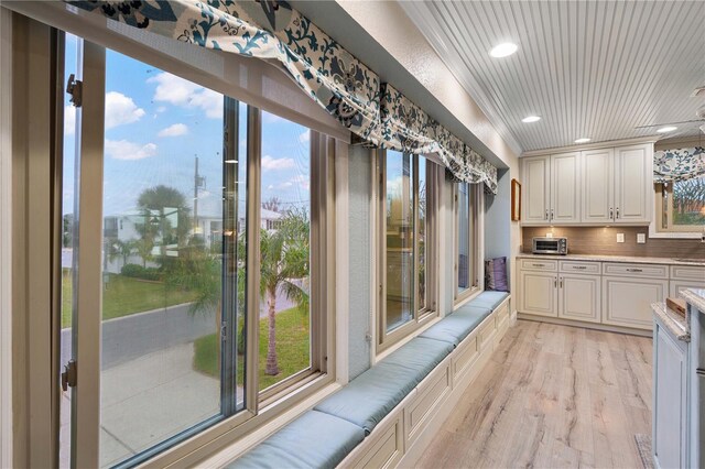 kitchen with white cabinets, decorative backsplash, wood ceiling, and light hardwood / wood-style flooring