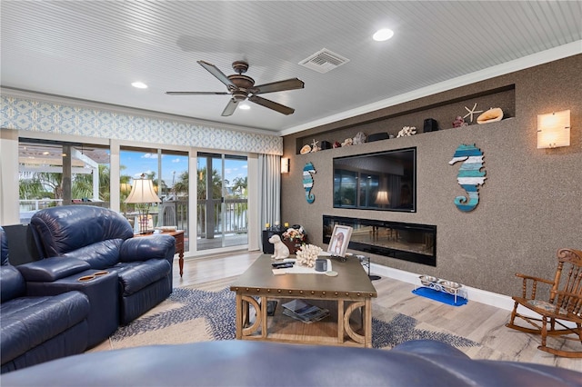 living room featuring light hardwood / wood-style floors, ceiling fan, and ornamental molding