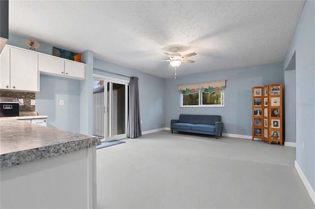 kitchen featuring white cabinets, ceiling fan, a textured ceiling, and tasteful backsplash