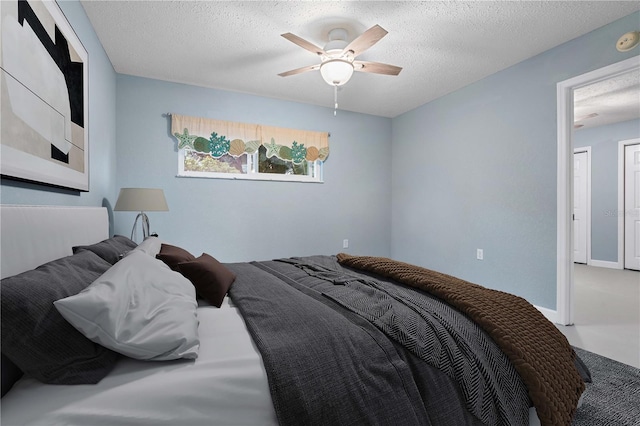 carpeted bedroom featuring a textured ceiling and ceiling fan