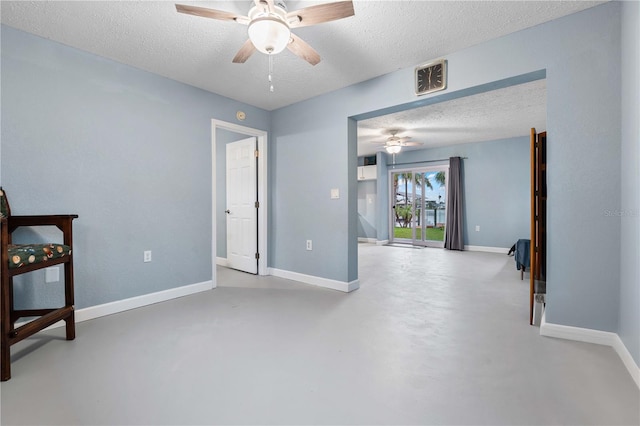 bedroom with ceiling fan, a textured ceiling, and concrete floors