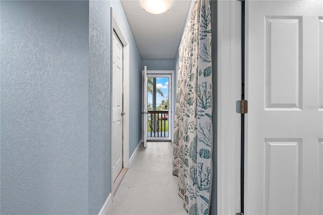 hall featuring a textured ceiling