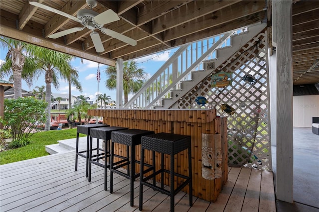 deck with a bar and ceiling fan