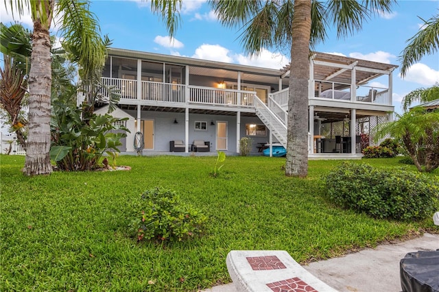 rear view of property with a sunroom and a yard