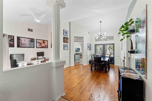 interior space with ornate columns, hanging light fixtures, high vaulted ceiling, wood-type flooring, and ceiling fan with notable chandelier