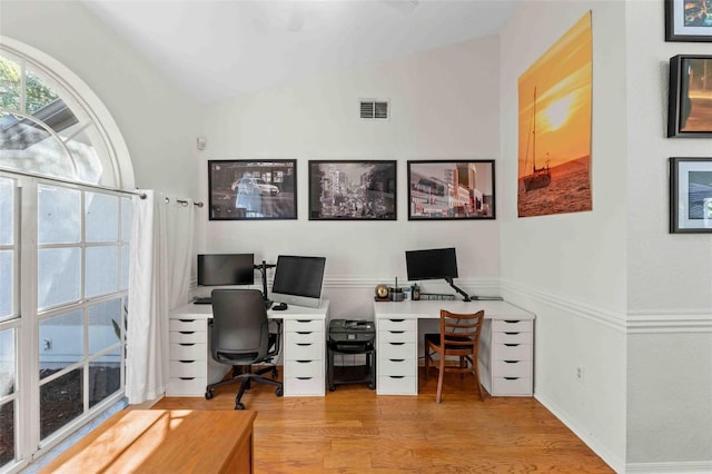 home office with light hardwood / wood-style flooring and vaulted ceiling