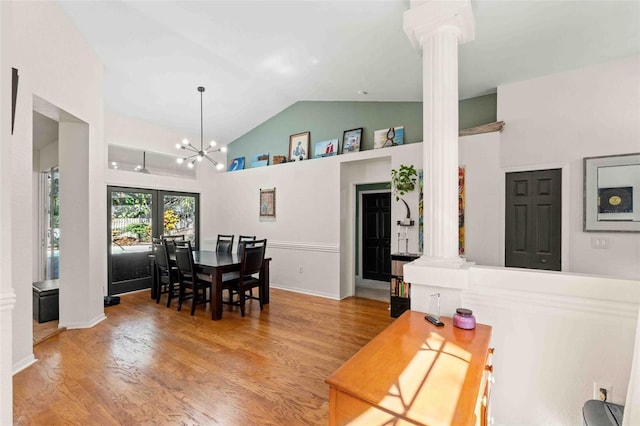 dining space featuring hardwood / wood-style flooring, ornate columns, french doors, and vaulted ceiling