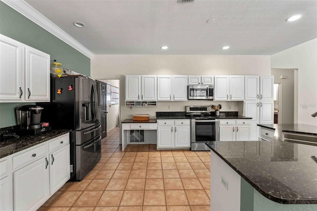 kitchen with crown molding, sink, light tile patterned floors, white cabinetry, and stainless steel appliances