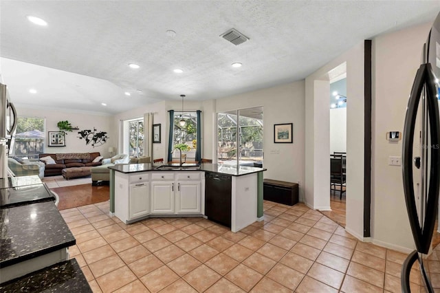 kitchen with a textured ceiling, stainless steel appliances, sink, light tile patterned floors, and white cabinets