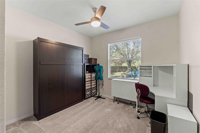 carpeted office space featuring ceiling fan