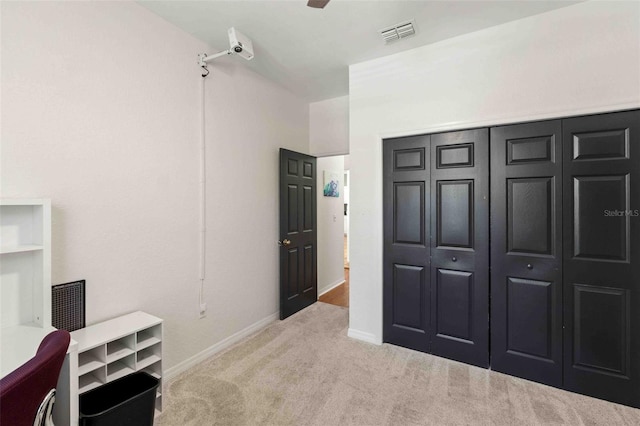 bedroom with light carpet and a closet