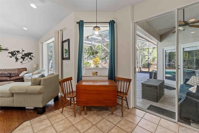 living area with ceiling fan, light wood-type flooring, ornamental molding, and vaulted ceiling