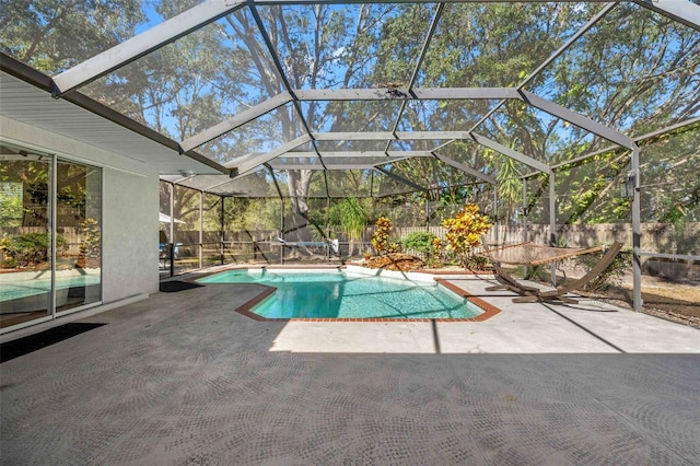 view of pool featuring glass enclosure and a patio