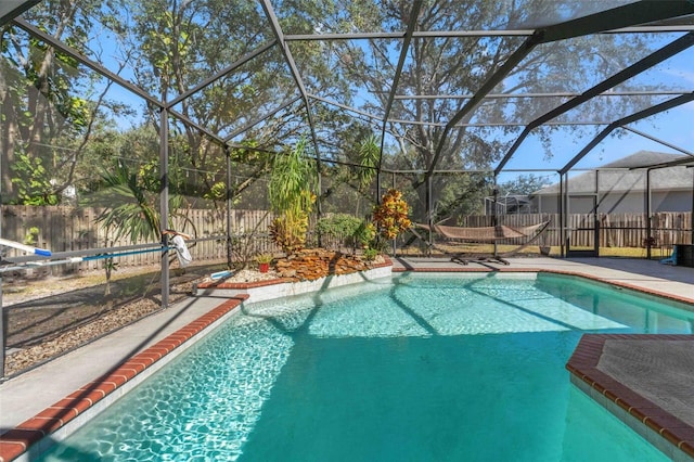 view of pool with glass enclosure and a patio