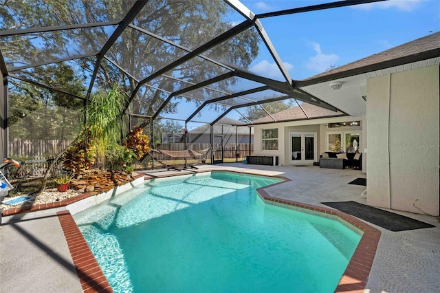 view of pool with french doors, a lanai, and a patio area