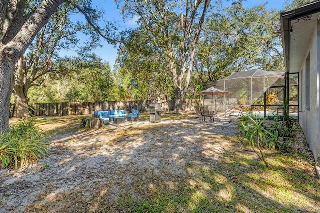 view of yard with a lanai, a patio, and an outdoor hangout area