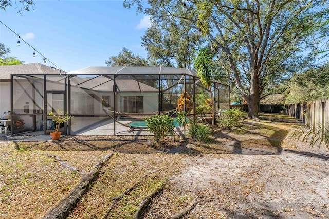 view of yard featuring glass enclosure and a patio area